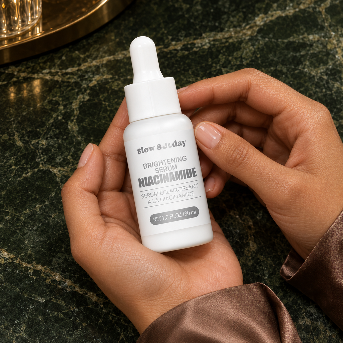 Slow Sunday Brightening Niacinamide Serum – 30 ml; closed bottle front-label detail in the same woman's hands