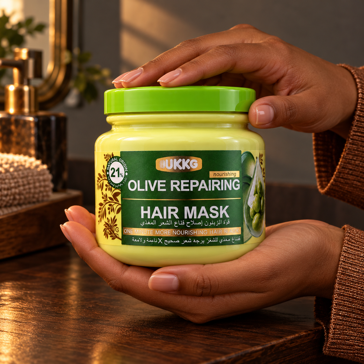UKKG Olive Repairing Hair Mask closed jar held in the same woman's hands above a wood vanity