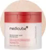 Round cotton toner pads soaked in clarifying kojic acid and turmeric solution in an open jar