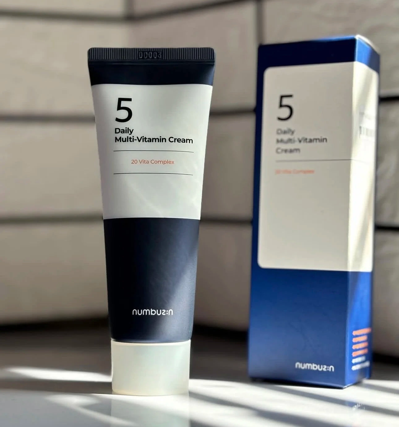 NUMBUZIN No.5 Daily Multi-Vitamin Brightening Cream — 20 Vita Complex — White and orange cream tube on white background