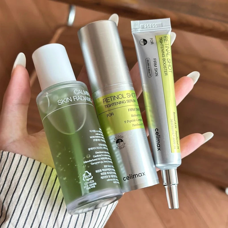 Celimax Retinol Firming Eye Cream & Noni Fruit Ampoule — Retinol & Noni — White and green squeeze tubes with pump bottle set on white background