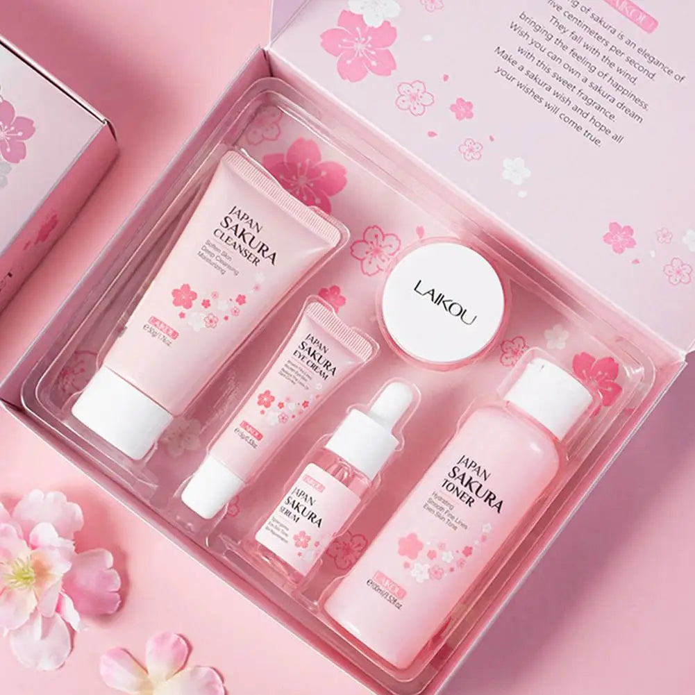 Six-piece facial brightening skincare set with sakura-themed packaging and assorted bottles, jars, and tubes.