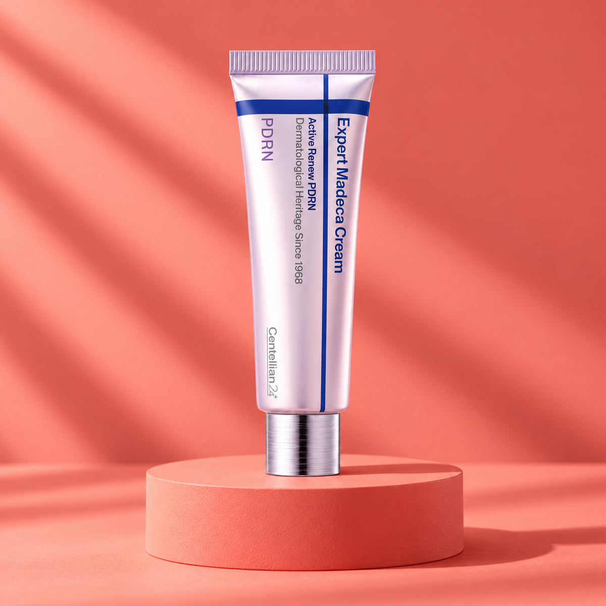 Closed Centellian24 Expert Madeca Cream Active Renew PDRN tube on a coral pedestal.