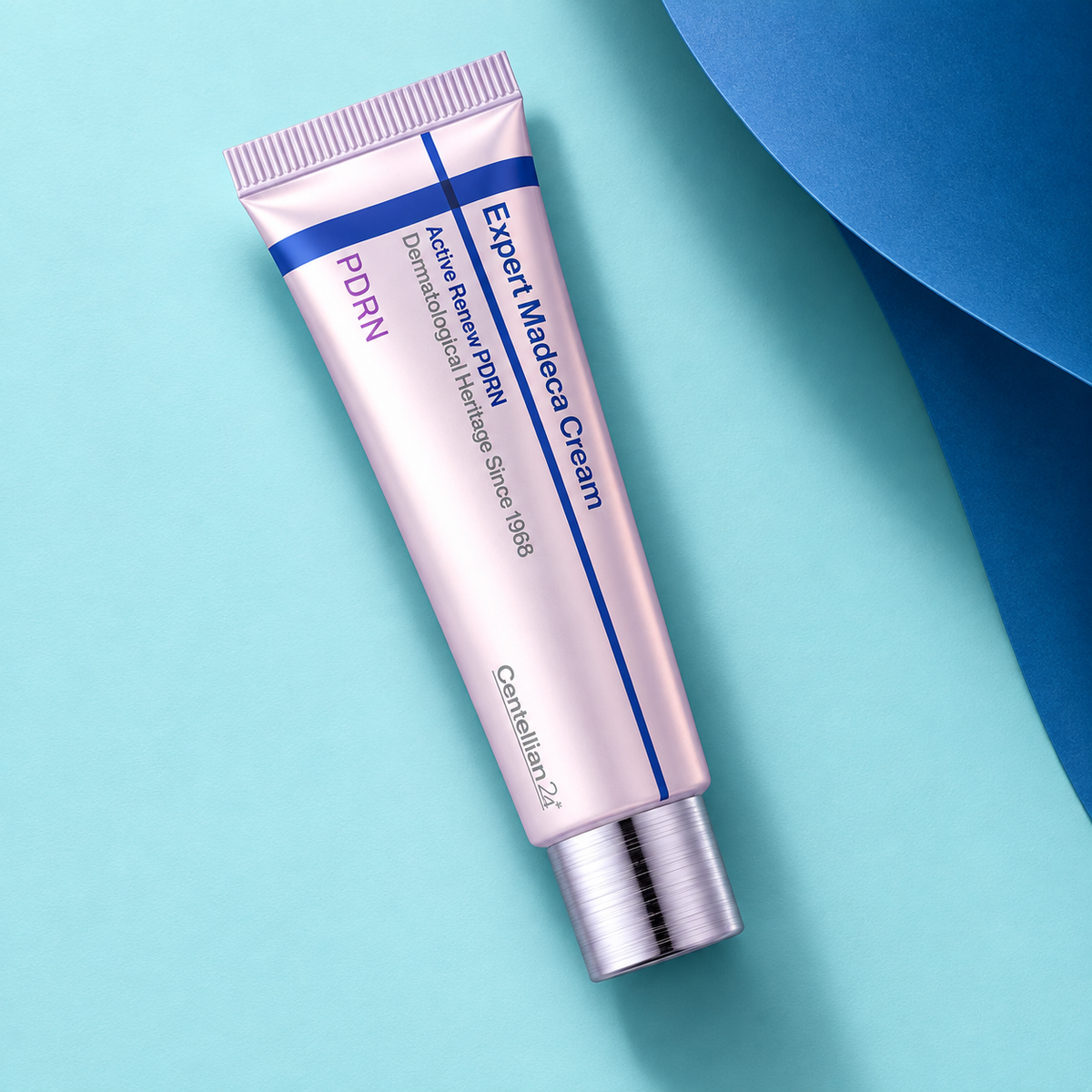 Centellian24 Expert Madeca Cream Active Renew PDRN tube in an aqua and blue flat lay.