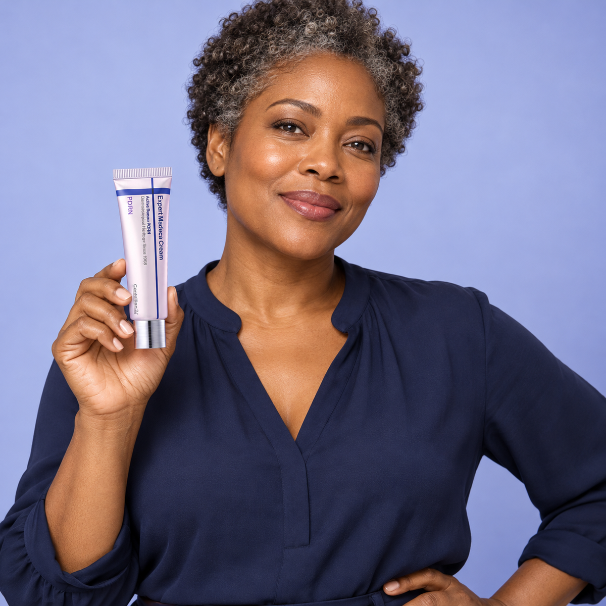 Adult model holding a closed Centellian24 Expert Madeca Cream Active Renew PDRN tube against a periwinkle backdrop.
