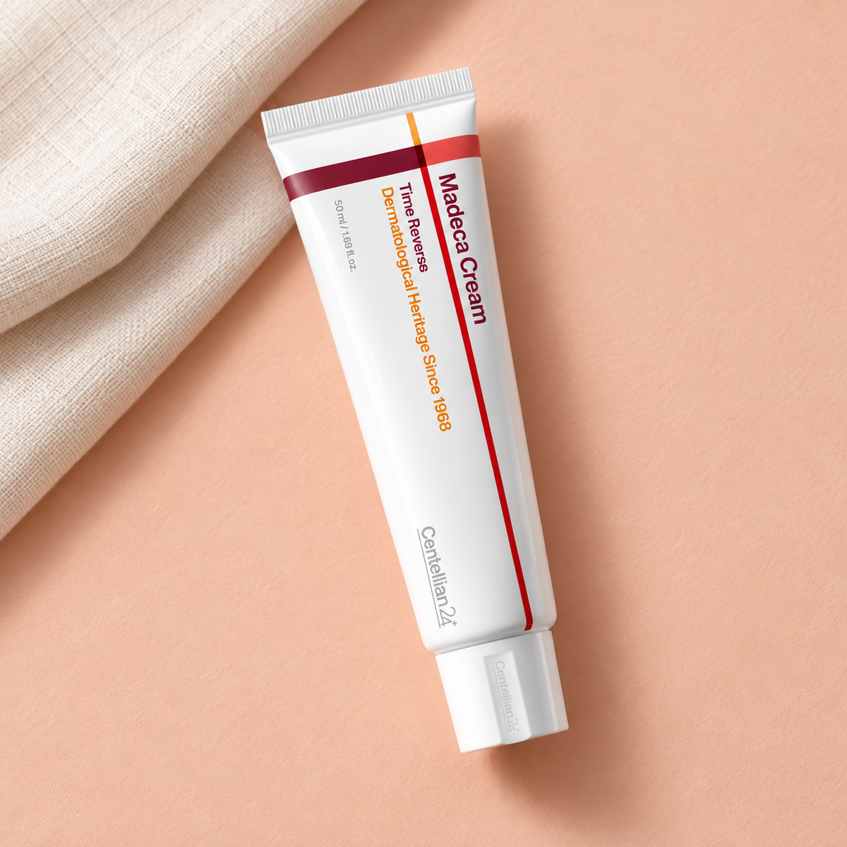 Centellian24 Madeca Cream Time Reverse 50 ml tube on a peach surface beside folded linen