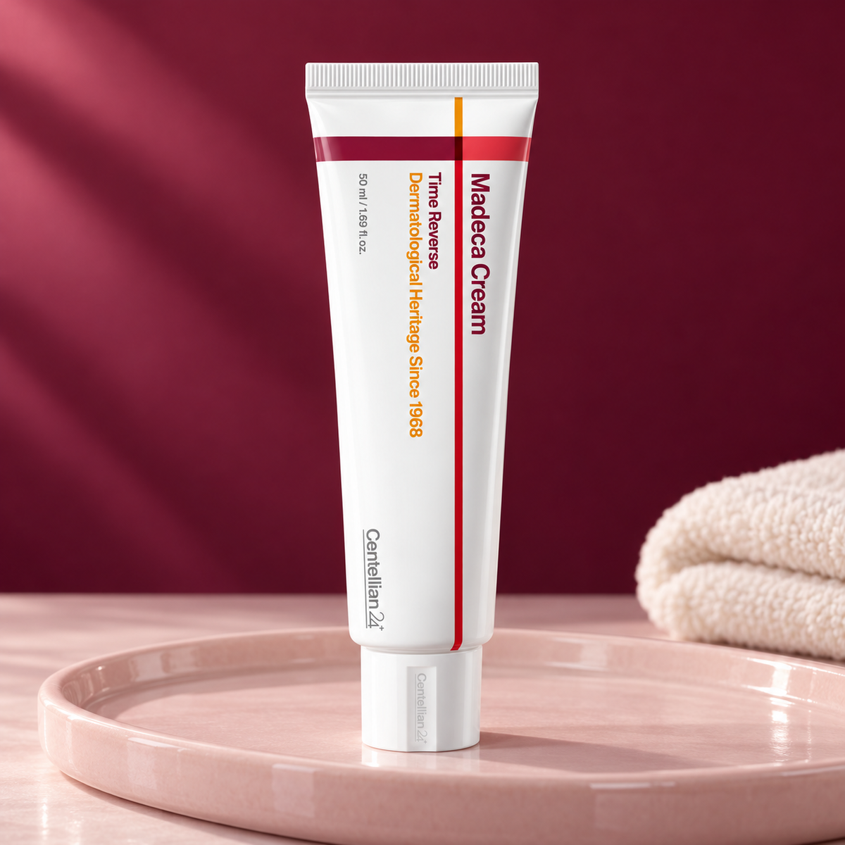 Centellian24 Madeca Cream Time Reverse 50 ml tube on a pink tray with a burgundy backdrop