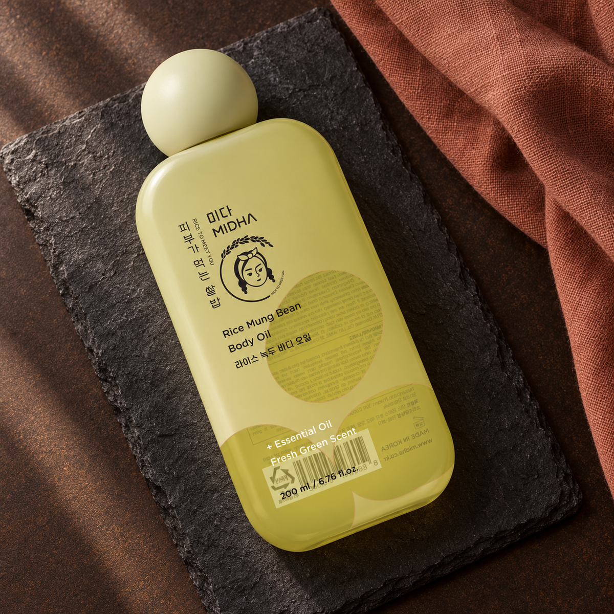 MIDHA Rice Mung Bean Body Oil 200 ml on charcoal slate with terracotta linen; AI-styled product presentation.