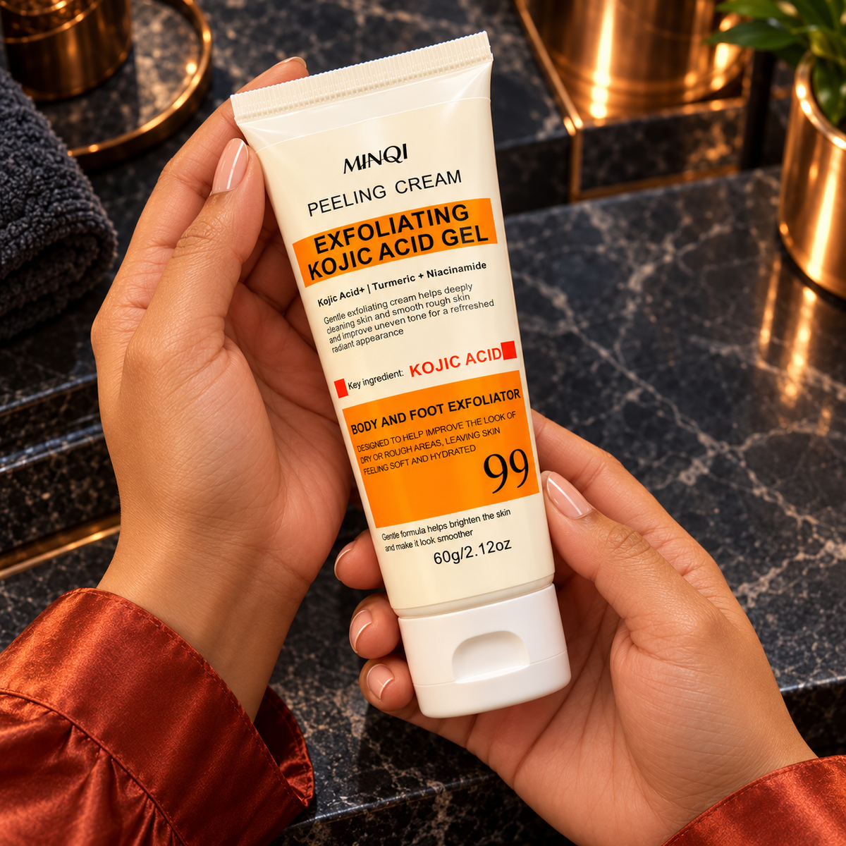 Close hand-held package detail of the MINQI Exfoliating Kojic Acid Gel 60 g unboxed closed tube, presented by the same woman