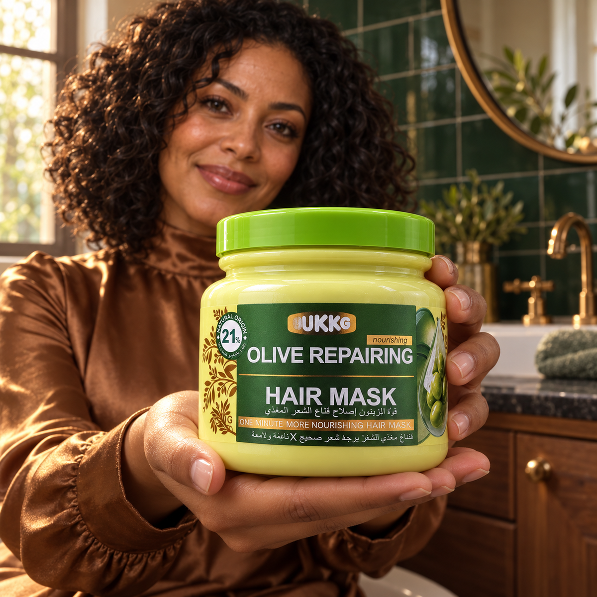 UKKG Olive Repairing Hair Mask closed jar presented by a woman in a green-tiled bathroom